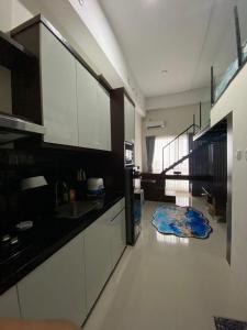 a kitchen with white cabinets and a blue rug on the floor at Loft apartment bintaro in South Tangerang