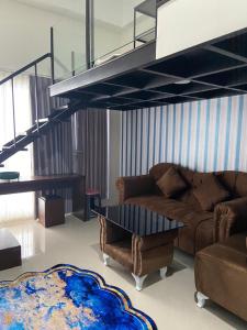a living room with a couch and a staircase at Loft apartment bintaro in South Tangerang