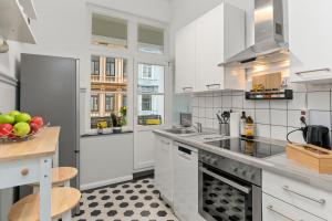 uma cozinha com armários brancos e uma taça de fruta em HOMEY Apartments - im Viertel mit Parkplatz em Bremen