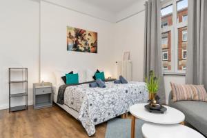 a white bedroom with a bed and a couch at HOMEY Apartments - im Viertel mit Parkplatz in Bremen