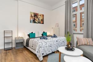 una camera bianca con un letto e un divano di HOMEY Apartments - im Viertel mit Parkplatz a Brema