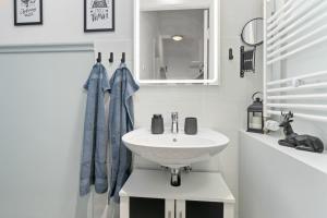 a white bathroom with a sink and a mirror at HOMEY Apartments - im Viertel mit Parkplatz in Bremen