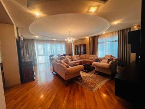una gran sala de estar con sofás y una mesa. en Azure residence, en Baku