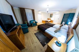 a hotel room with a large bed and a flat screen tv at Pension Sólyomkő in Bixad