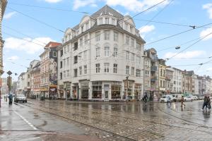 a large white building on a rainy city street at HOMEY Apartments - im Viertel mit Parkplatz in Bremen