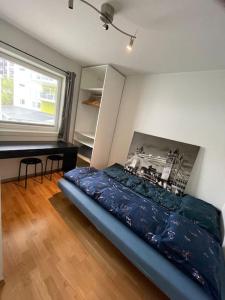 a bedroom with a bed and a desk next to a window at 84m2 3 sleeping rooms which direct traffic to airport and city center in Bergen