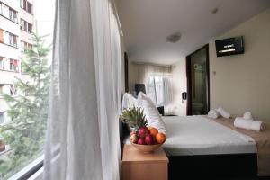 貝爾格勒的住宿－快樂星俱樂部酒店，一间卧室,配有一张床上的床铺,桌上放着一碗水果