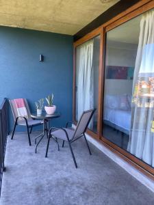 - une chambre avec une table et des chaises dans l'établissement Apart Hotel Sol y Lago, à Pucón