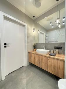 a bathroom with a sink and a large mirror at Old Town Nadmotławie - Sauna & Gym I 10min deptak in Gdańsk