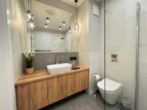 a bathroom with a sink and a toilet and a mirror at Old Town Nadmotławie - Sauna & Gym I 10min deptak in Gdańsk