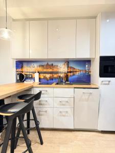 a kitchen with white cabinets and a table and chairs at Old Town Nadmotławie - Sauna & Gym I 10min deptak in Gdańsk
