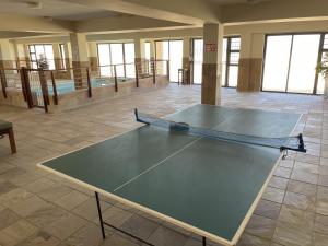 a ping pong table in the middle of a room at Paradise Beachfront Apartment in Jeffreys Bay
