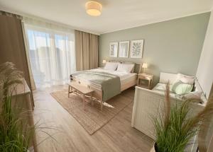 a bedroom with a bed and a couch at Apartment Strandzeit in Kölpinsee