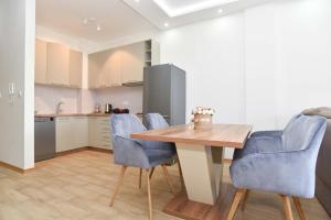 a kitchen with a wooden table and blue chairs at KAAN APARTMENT in Budva