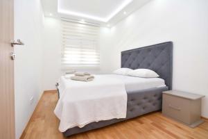 a bedroom with a large bed with white sheets at KAAN APARTMENT in Budva