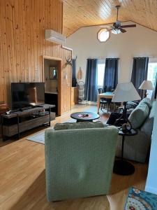 ein Wohnzimmer mit einem Sofa und einem TV in der Unterkunft MLR - Lakeview Cabin 