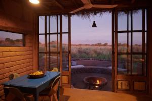 Zimmer mit einem Tisch und Blick auf ein Feld in der Unterkunft Casa Chincol in San Pedro de Atacama