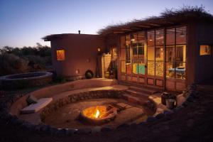 a house with a fire pit in the yard at Casa Chincol in San Pedro de Atacama