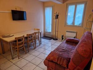 ein Wohnzimmer mit einem Tisch und einem Sofa in der Unterkunft Asphodèle, T2 bis, extérieur, wifi, parking, 6 personnes in Cauterets