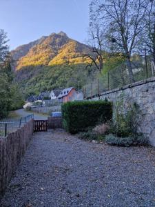 un mur en pierre avec un banc en face d'une montagne dans l'établissement Asphodèle, T2 bis, extérieur, wifi, parking, 6 personnes, à Cauterets