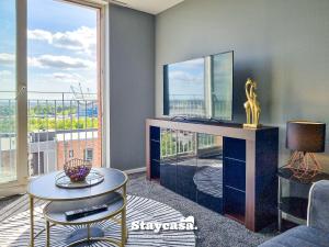 a living room with a tv and a table and a window at Luxury 1 Bed Apartment Beautiful View With Parking in Manchester