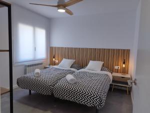a bedroom with a bed with a black and white comforter at Apartaments IXA in Manresa
