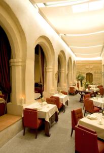 セゴビアにあるホテル サン アントニオ エル レアルのテーブルと椅子が備わるレストラン