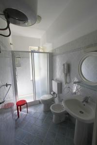 a bathroom with a sink and a toilet and a mirror at Hotel Holiday Bambù in Marciana