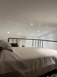 een bed in een witte kamer met een nachtrok, spectspectspectspectspectal bij Apartamento cerca al parque in Jardin