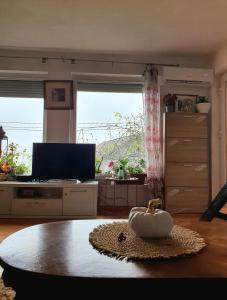 a living room with a table and a large window at Melisa Apartment Sarajevo in Sarajevo