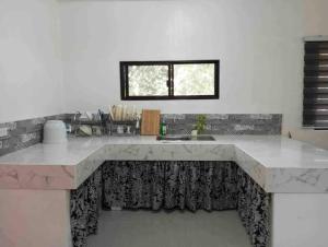 a kitchen with a large counter with a sink at Taylors Country Home/Travellers Inn- The Bungalow in Catarman