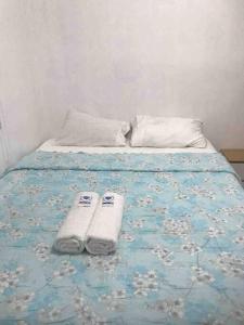 uma cama com duas toalhas em cima em Taylors Country Home/Travellers Inn- The Bungalow em Catarman