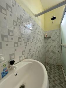 a white bath tub in a bathroom with tiles at Unique apartment 2 in Mombasa