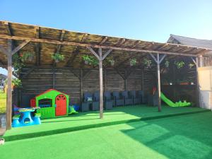 uma área recreativa para crianças com uma caixa de areia e uma casa de brincar em Soimii Bucovinei Residence em Vatra Moldoviţei