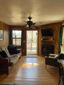 a living room with a couch and a ceiling fan at Private cozy cabin in the woods with great view in Murphy