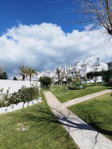 a path through a park with white houses at ATLANTERRA PUEBLO in Zahara de los Atunes