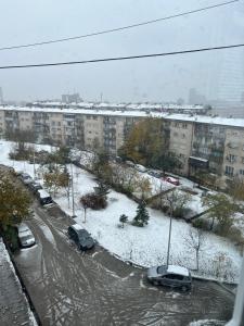 un parcheggio con auto parcheggiate nella neve di Dielli Apartment New a Pristina