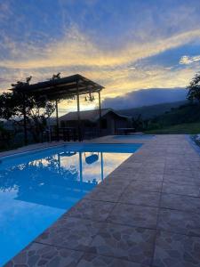 einen Pool mit Pavillon neben einem Haus in der Unterkunft Cabaña Niraj in Cartago