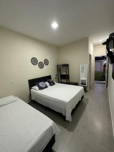 a bedroom with two beds and a tv in it at Residencial 220 Maresias in Maresias