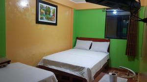 Habitación con 2 camas y pared verde. en Hospedaje Escorpio en Lima