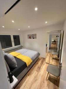 a bedroom with a bed and a chair and a table at Penthouse, Offenburg,Europapark in Offenburg