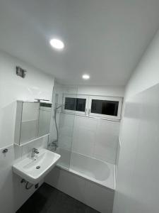 a white bathroom with a sink and a mirror at Penthouse, Offenburg,Europapark in Offenburg