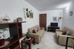 ein Wohnzimmer mit 2 Sofas und einem TV in der Unterkunft Sinta-se em Casa Longe de Casa in Taboão da Serra