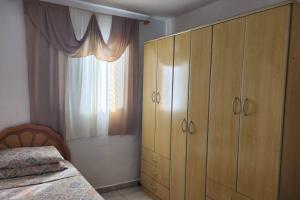 塔博昂達塞拉的住宿－Sinta-se em Casa Longe de Casa，一间卧室配有一张床、一个梳妆台和一扇窗户。