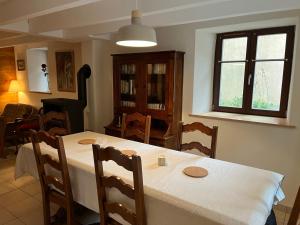 a dining room with a white table and chairs at Le cordonnier du Staedel in La Petite-Pierre