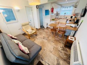 uma sala de estar com um sofá e uma cozinha em 2 Bedroom Chalet SB109, Sandown Bay, Isle of Wight em Brading