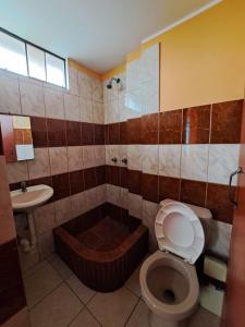 La salle de bains est pourvue de toilettes, d'une baignoire et d'un lavabo. dans l'établissement Hospedaje Escorpio, à Lima