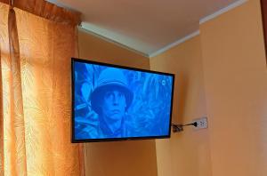 einen Flachbild-TV, der an einer Wand hängt in der Unterkunft Hospedaje Escorpio in Lima