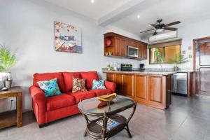 sala de estar con sofá rojo y cocina en Magical 1 Bedroom Condo with Ocean View & Pool, en Potrero
