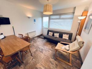 uma sala de estar com um sofá e uma mesa em 2 Bedroom Chalet SB109, Sandown Bay, Isle of Wight em Brading